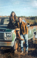 personalized photo puzzle made into a wedding guest book with 150 pieces for a large wedding guest list.  Woman is sitting on older ford truck in field, with man leaning on truck   The Missing Piece Puzzzle Co.