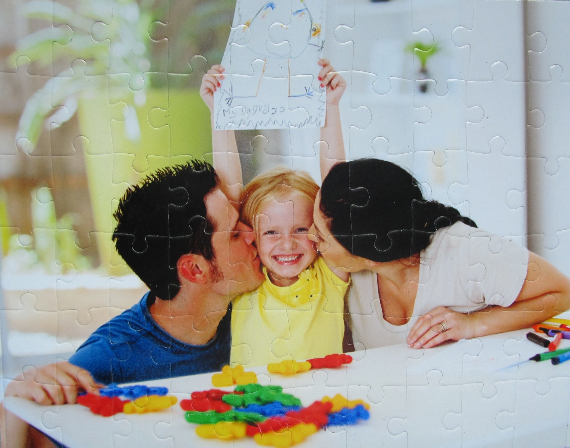 Cheap Custom Puzzle Gift!  Custom puzzle gift.  Showing mom and dad kissing child on each cheek and child loves her custom puzzle. The Missing Piece Puzzle Company