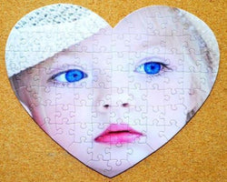 Mothers day gift of a custom heart shaped personalized puzzle.  This heart shaped custom puzzle shows a baby with bright blue eyes.